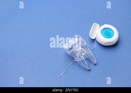 Case with dental floss and model of tooth on blue background Stock ...