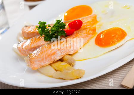 Fried salmon with scrambled eggs and asparagus Stock Photo