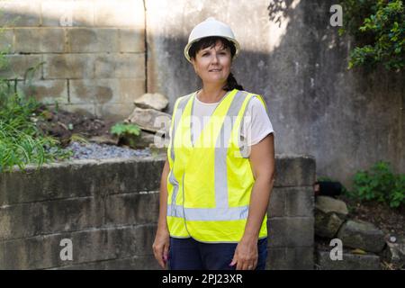 Mature Female Industrial Worker. Road, construction site, waste Stock Photo