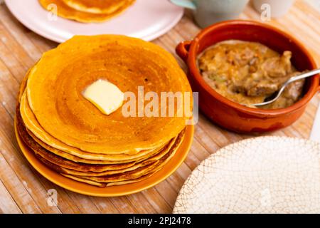 Thin pancakes with butter and mochanka of meat and mushrooms Stock Photo