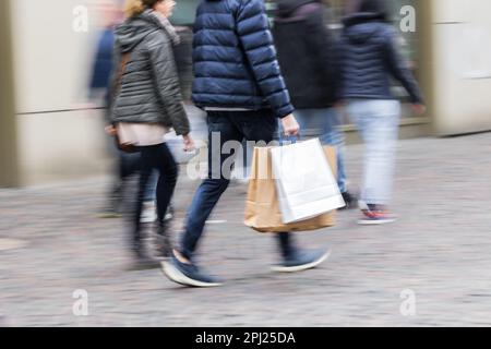 picture with motion blur of a shopping couple walking in a pedestrian area of a city Stock Photo