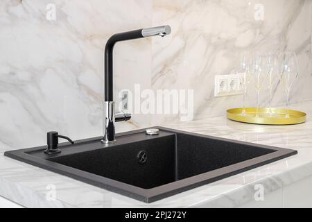 Black faucet and granite sink in the kitchen Stock Photo