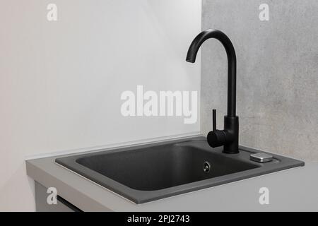 Black faucet and granite sink in the kitchen Stock Photo