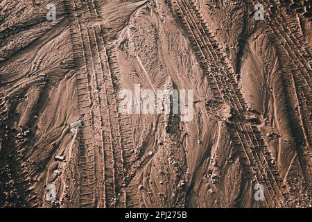 Tire tracks and swirls on wet sand Stock Photo