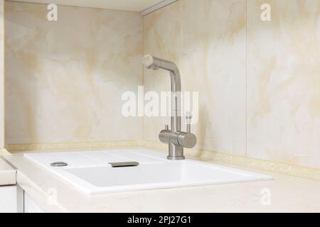 Faucet with white granite sink in the kitchen Stock Photo