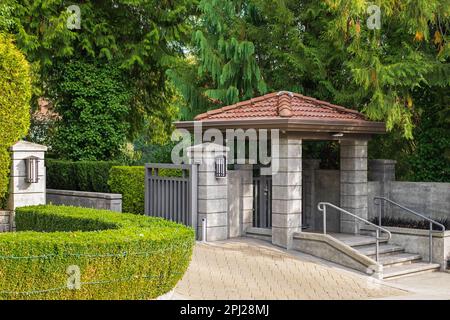 Iron front gate of a beautiful luxury home with landscaping. Gateway of a Country Mansion. Manor gate. Nobody, street photo, selective focus Stock Photo