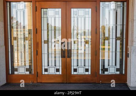 Stain glass door. Front Entrance of a traditional house with mission style stained wood door. Glass front door. Nobody, selective focus, street photo Stock Photo