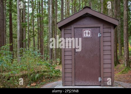 Public toilet in park. Summer day Wooden restroom or toilet building in remote forest in park. Bathrooms or WC. Nobody, street photo, selective focus Stock Photo