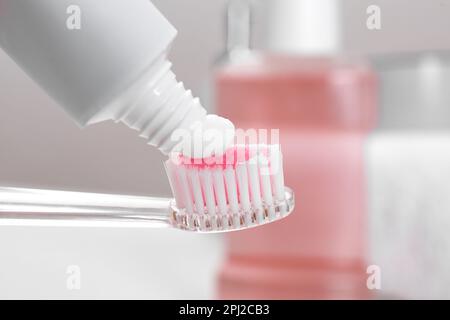 Applying paste on toothbrush near mouthwash, closeup Stock Photo