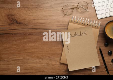 Flat lay composition with unfilled To Do list and glasses on wooden table, space for text Stock Photo