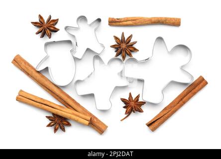 Different cookie cutters, cinnamon sticks and anise stars on white background, top view Stock Photo