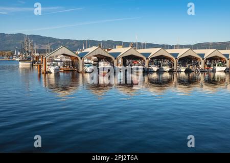 Boat houses at marina at port Alberni Vancouver Island Canada. Boat Sheds on the water at harbour in a sunny summer day. Travel photo, nobody-October Stock Photo