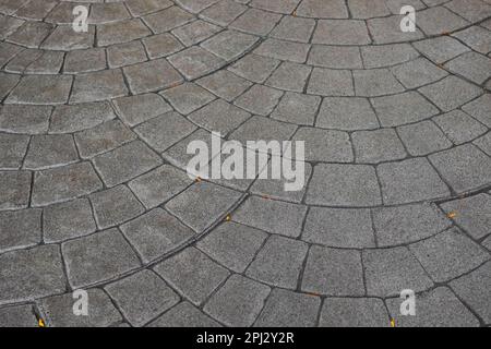 Stamped concrete pavement cobblestones pattern, decorative appearance textures of paving cobblestones tile on cement flooring in a park. Printed grey Stock Photo