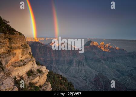 Brief evening light during a summer monsoon rain storm creates this brilliant double rainbow over the four temples from Bright Angel Point on the Nort Stock Photo