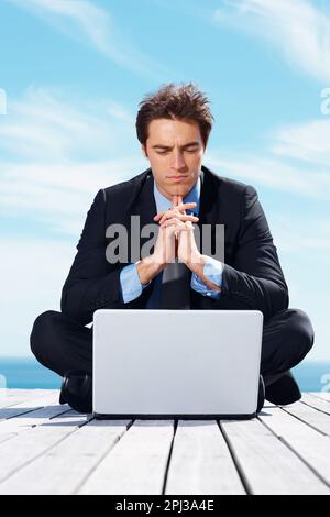 Serious young business man using a laptop outdoors. Serious young business man using a laptop computer outdoors. Stock Photo
