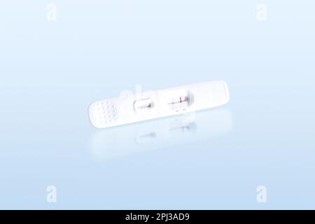 Negative antigen test of antigen test cassette isolated on blue background with reflection, Medical instrument concept, clipping path included. Stock Photo