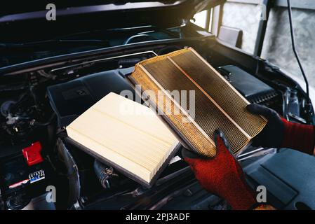 Auto mechanic checking the clogged air filter of a car, Car maintenance service concept. Stock Photo
