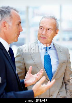 Two senior executives having discussion. Two senior executives having conversation indoors. Stock Photo