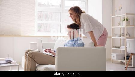 Family Couple Using Laptop On Couch Online Stock Photo