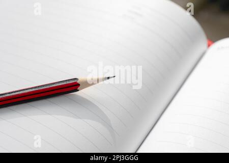 A wooden pencil placed on an opened book. Edited photo. Stock Photo