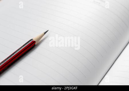 A wooden pencil placed on an opened book. Edited photo. Stock Photo