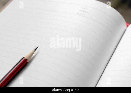 A wooden pencil placed on an opened book. Edited photo. Stock Photo