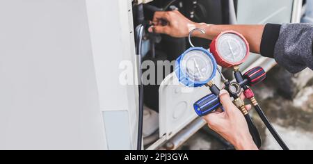 technician checks the operation of the air conditioner. Stock Photo
