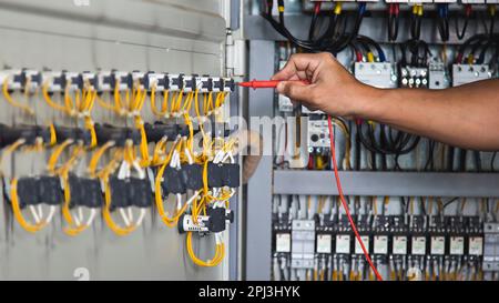 Electrical engineer checking the operation of electrical control cabinet, maintenance concept. Stock Photo