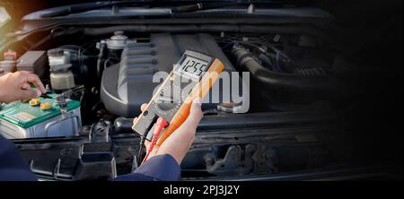 Technician checking car battery voltage Stock Photo
