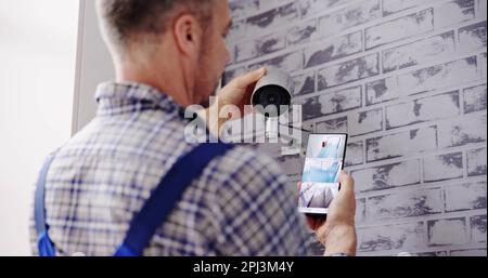 Technician Adjusting CCTV Camera For Video Surveillance Stock Photo