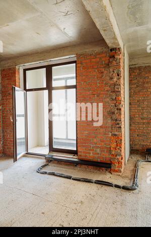 View of Repair and restoration of apartments. Red brick walls, concrete floors ...