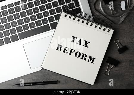 Notebook with text TAX REFORM, laptop and stationery on grey table, flat lay Stock Photo