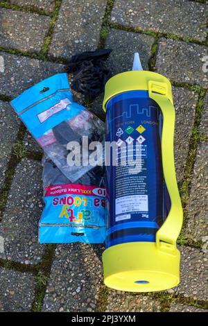 nitrous oxide or laughing gas cylinder for recreational drug usage left on street with balloons in Niewerkerk aan den IJssel Stock Photo