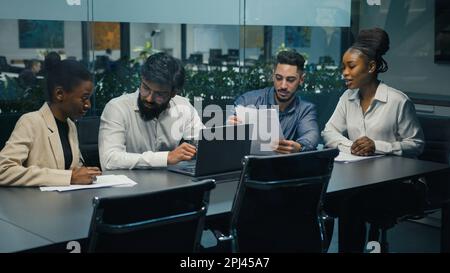 Creative diverse multiracial professional multiethnic business team partners workers colleagues working together discussing project ideas with laptop Stock Photo
