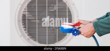 technician checks the operation of the air conditioner. Stock Photo