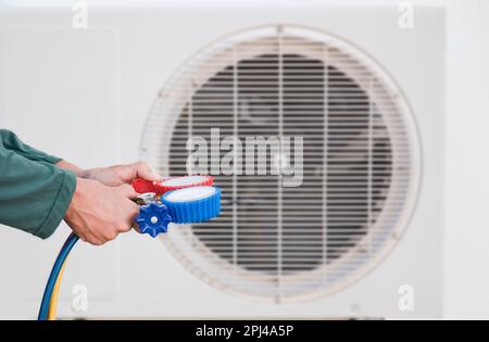 technician checks the operation of the air conditioner. Stock Photo