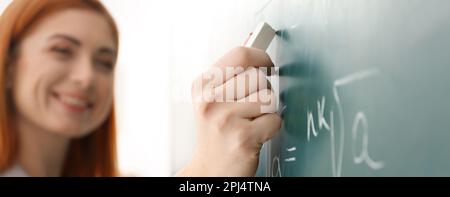 Teacher writing on chalkboard in classroom, closeup. Banner design Stock Photo
