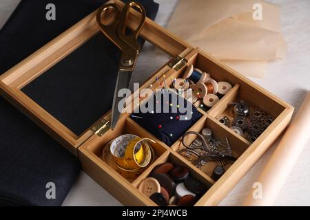 Set of sewing supplies and accessories in wooden organizer on white table Stock Photo