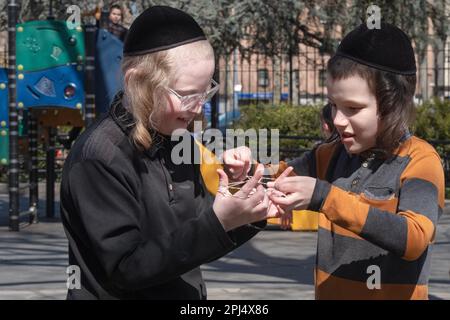 During recess, 2 orthodox Jewish students with long peyes play Cat's Cradle, a game palyed with string. In Brooklyn, New York. Stock Photo