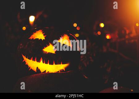 Scary halloween pumpkin on wooden planks, spooky jack lanterns on field in forest at night Stock Photo