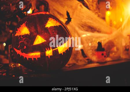 Scary halloween pumpkin on wooden planks, spooky jack lanterns on field in forest at night Stock Photo