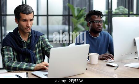 Managers with laptop sitting in modern office Stock Photo