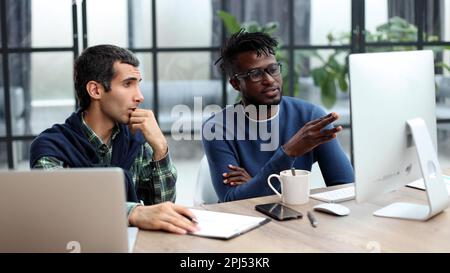 Business people working together in a modern trendy office behind a laptop Stock Photo