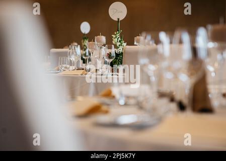 A wedding celebration with tables topped with an array of empty glasses and plates Stock Photo