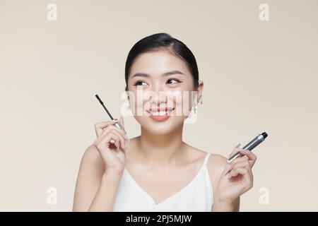 Charming young woman applying mascara. Stock Photo
