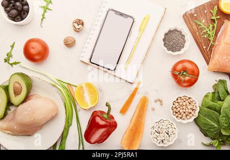 Fodmap, Mediterranean, Paleo diet concept. Healthy low fodmap food - vegetables, meat, fish, chickpeas, fruits. Screen mobile phone mockup. Stock Photo