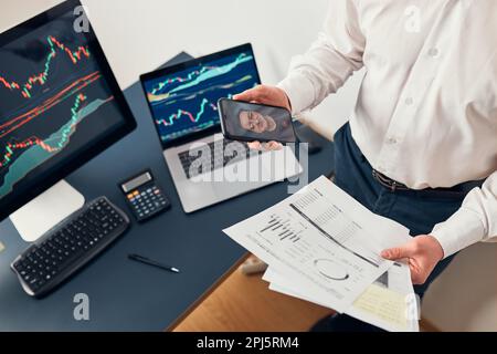 Businessman trading stocks online. Stock investor discussing numbers at graphs while video conversation with his colleague. Business team planning and Stock Photo