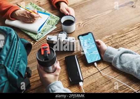 Family planning vacation trip. Girl searching travel destination and routes using navigation map on mobile phone. Woman writing journal and making not Stock Photo