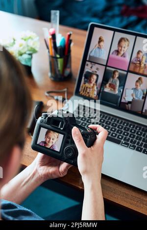 Female photographer working on photos on laptop and camera. Woman editing retouching browsing photos working as a freelancer sitting at desk Stock Photo