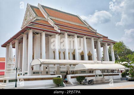 A white temple with detailed decorated roof with many colorful ornaments at Wat Mahannapharam Worawihan temple in Bangkok in Thailand. Stock Photo